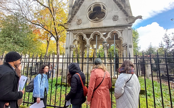 Visitors exploring a mausoleum at Père Lachaise Cemetery, France.
