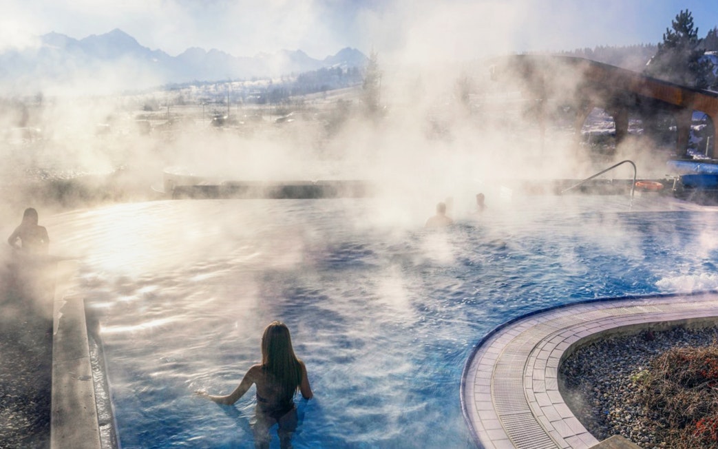 Visitors enjoying the steaming outdoor pool at Chocholow Thermal Baths, Poland.