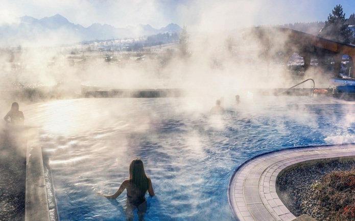 Visitors enjoying the steaming outdoor pool at Chocholow Thermal Baths, Poland.