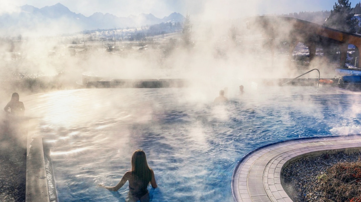 Visitors enjoying the steaming outdoor pool at Chocholow Thermal Baths, Poland.