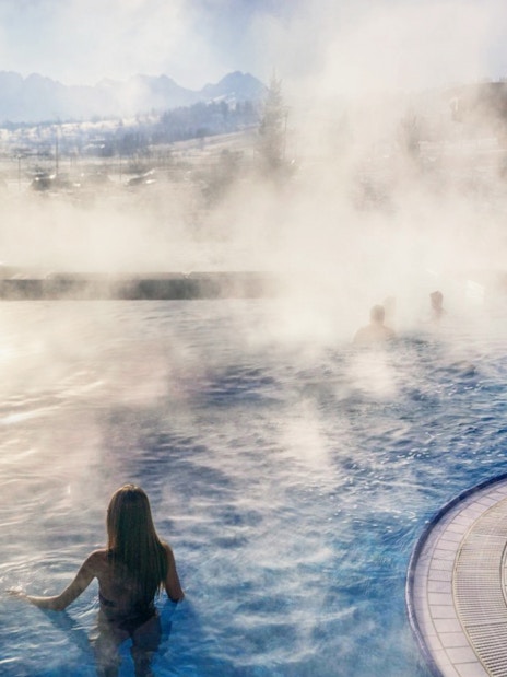 Visitors enjoying the steaming outdoor pool at Chocholow Thermal Baths, Poland.