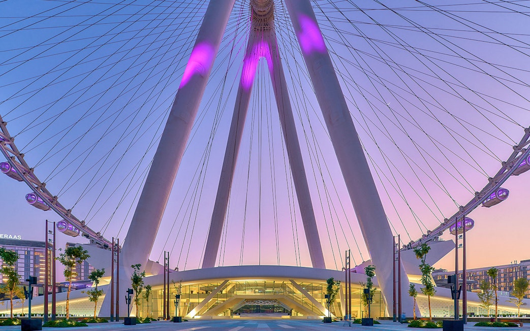 Ain Dubai Ferris wheel at sunset, Dubai skyline in background.