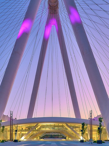 Ain Dubai Ferris wheel at sunset, Dubai skyline in background.