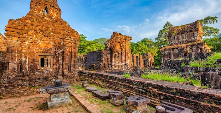 Ancient brick temples at My Son Sanctuary, Vietnam, surrounded by lush greenery.