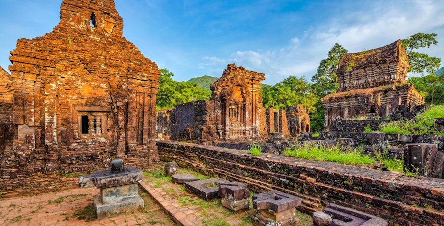 Ancient brick temples at My Son Sanctuary, Vietnam, surrounded by lush greenery.