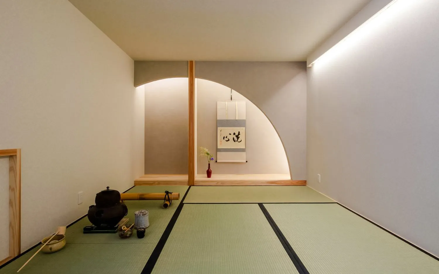 Kyoto tea ceremony room with tatami mats, tea set, and traditional scroll.