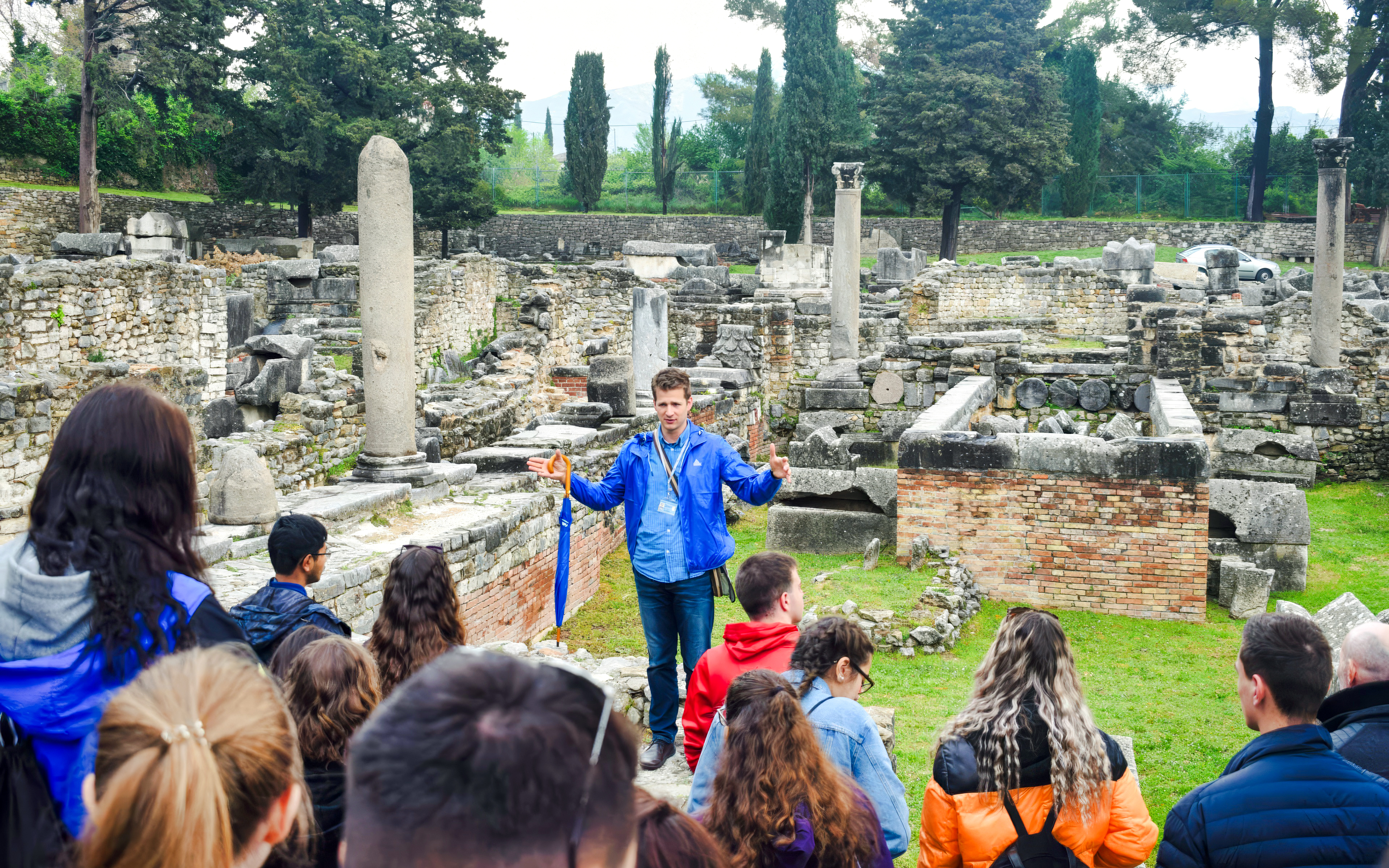 Tour guide explaining Roman ruins of Salona to visitors in Solin, Croatia.