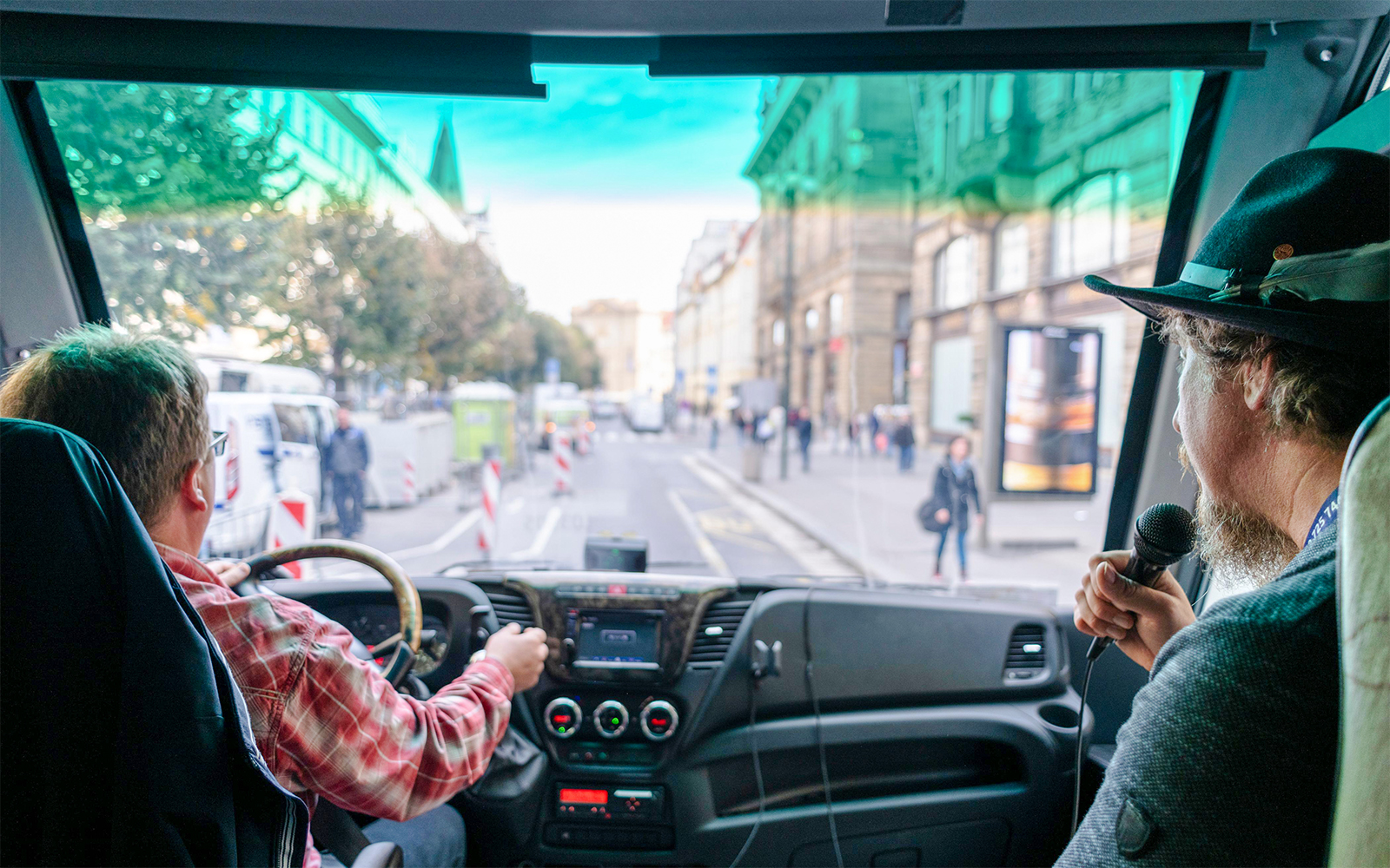 Tour guide speaking inside bus during Prague Castle guided tour transfer.