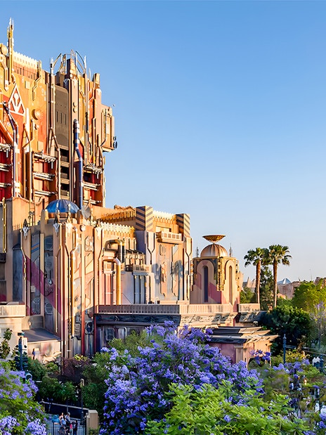 Guardians of the Galaxy attraction at Disneyland Adventure Park, California, surrounded by palm trees and flowers.