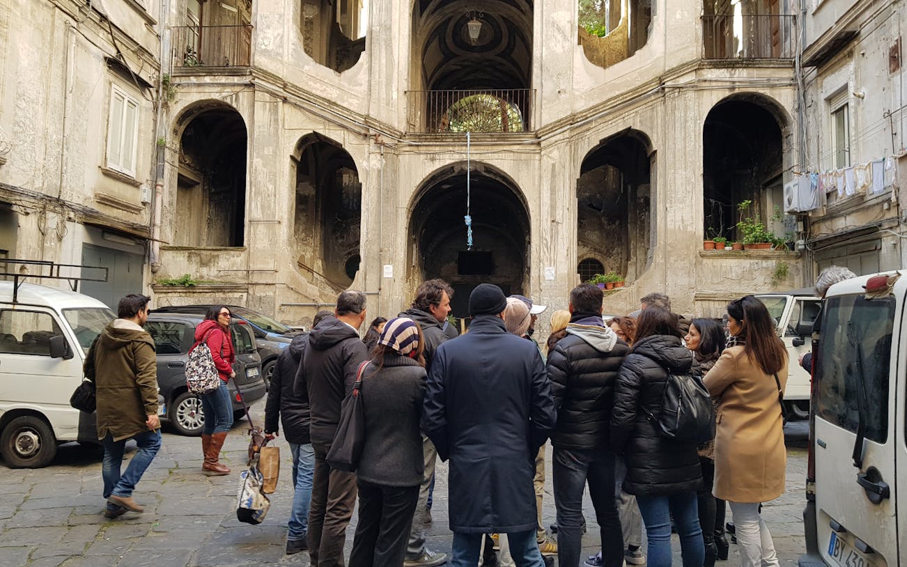 Group exploring historic architecture on a walking tour of Rione Sanità, Naples.