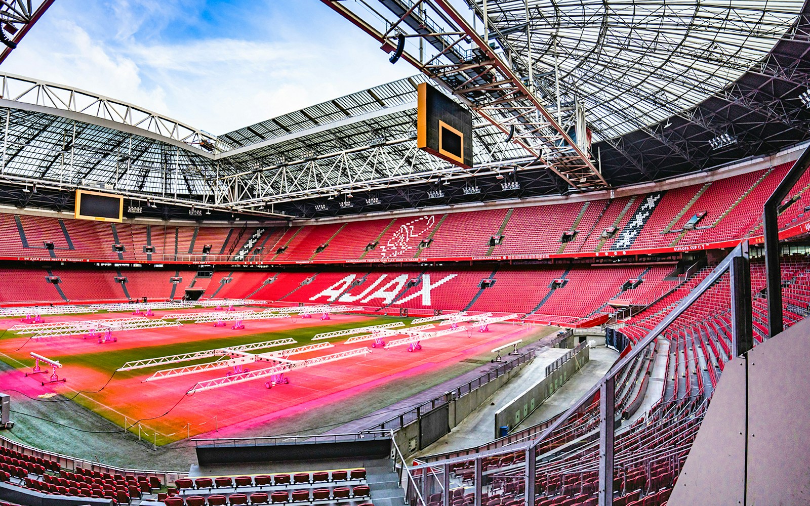 Johan Cruijff ArenA interior with empty red seats and field, Amsterdam.