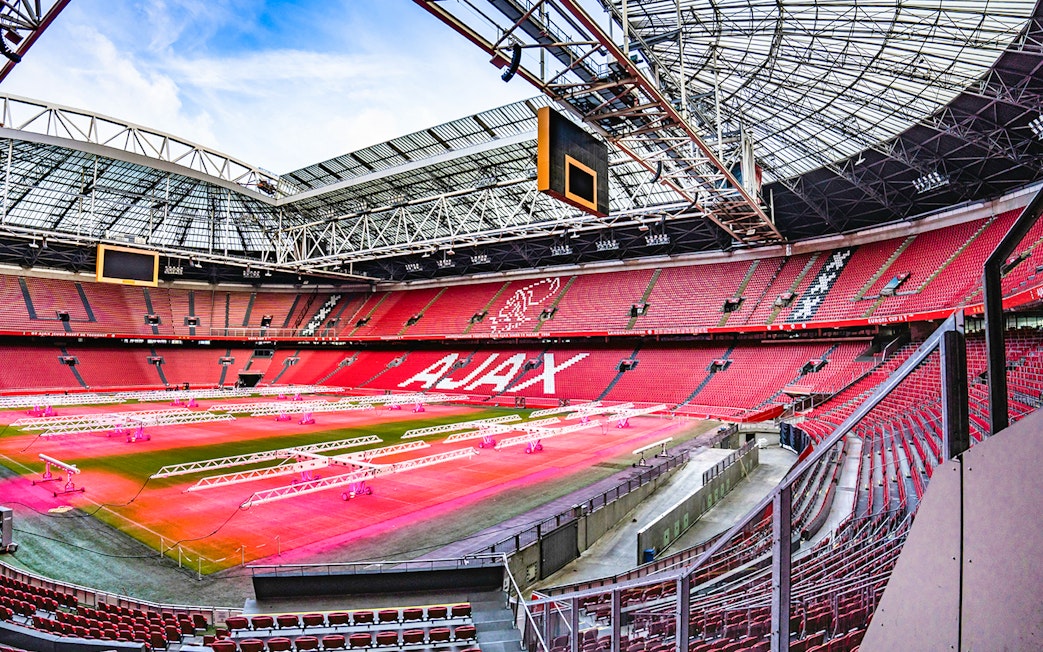 Johan Cruijff ArenA interior with empty red seats and field, Amsterdam.