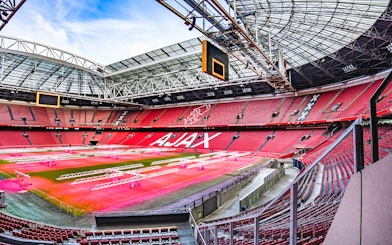 Johan Cruijff ArenA interior with empty red seats and field, Amsterdam.