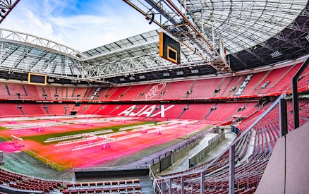 Johan Cruijff ArenA interior with empty red seats and field, Amsterdam.