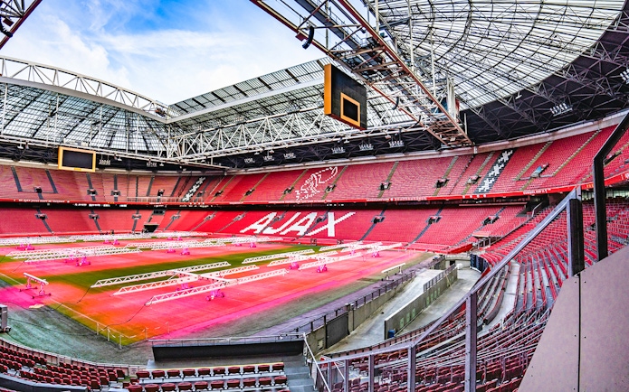 Johan Cruijff ArenA interior with empty red seats and field, Amsterdam.