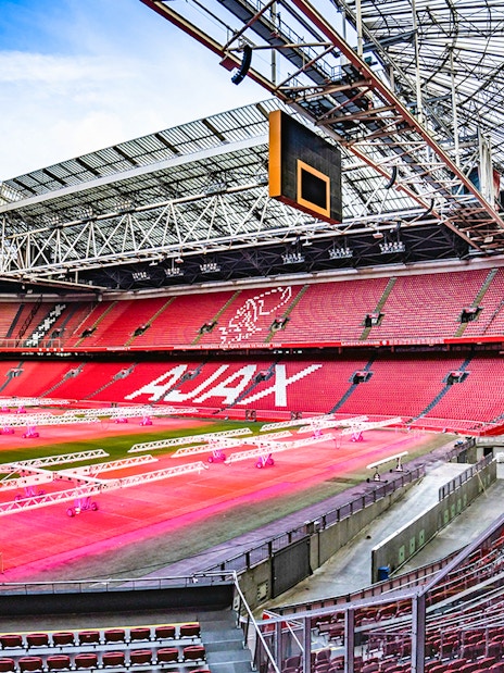 Johan Cruijff ArenA interior with empty red seats and field, Amsterdam.