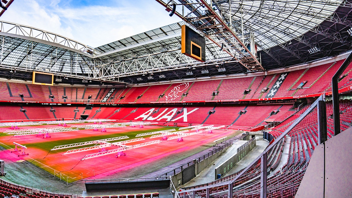 Johan Cruijff ArenA interior with empty red seats and field, Amsterdam.
