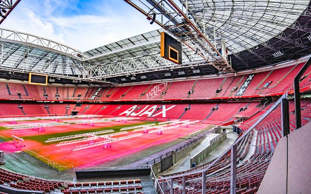 Johan Cruijff ArenA interior with empty red seats and field, Amsterdam.