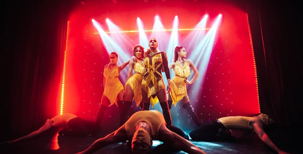 Performers in vibrant costumes on stage at Billionaire Dubai's luxury dining experience.