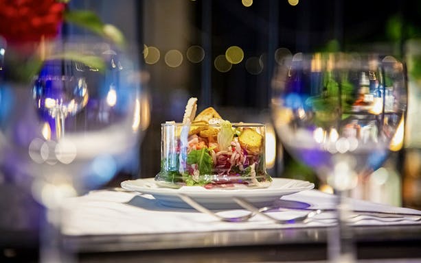 Chef preparing Czech tapas dish during cuisine tasting tour.
