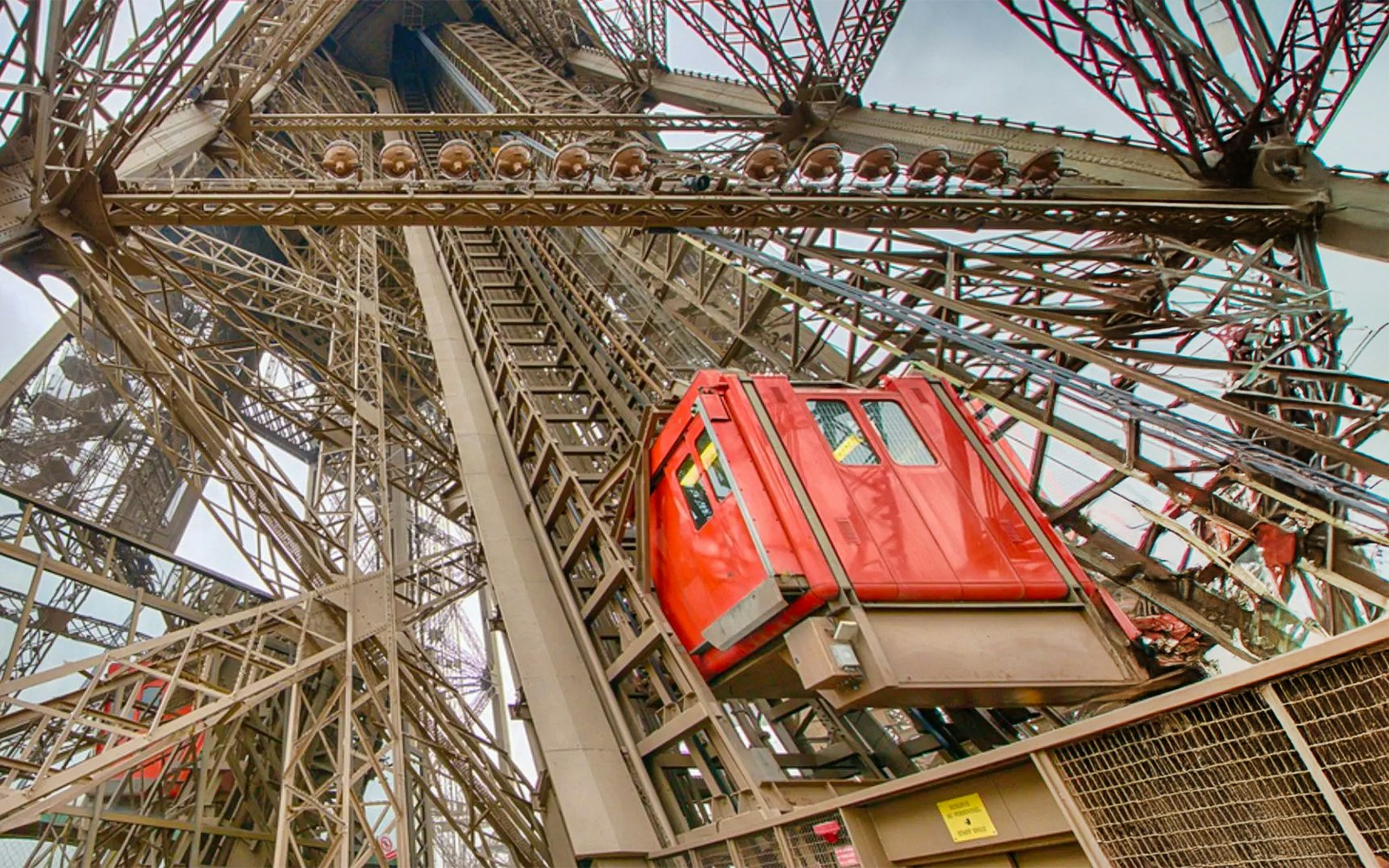 Eiffel Tower elevator ascending through iron structure in Paris.
