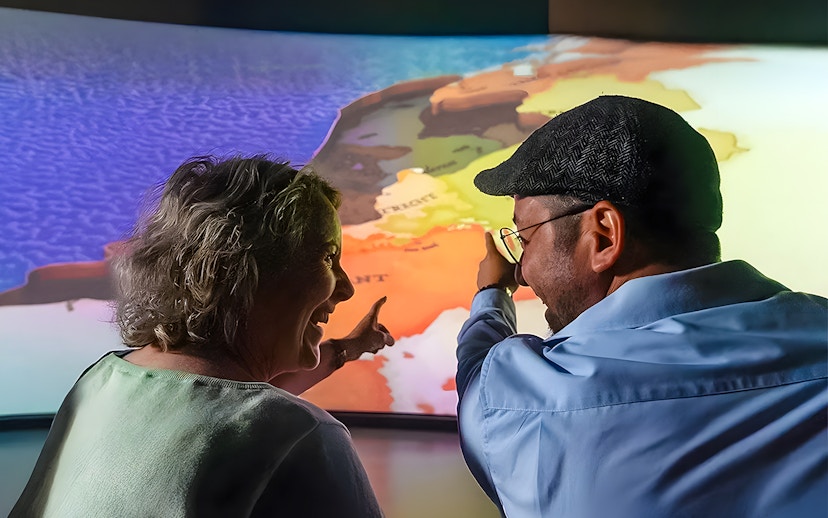 Tourists pointing at map during 5D ride at This Is Holland Ultimate Flight Experience.