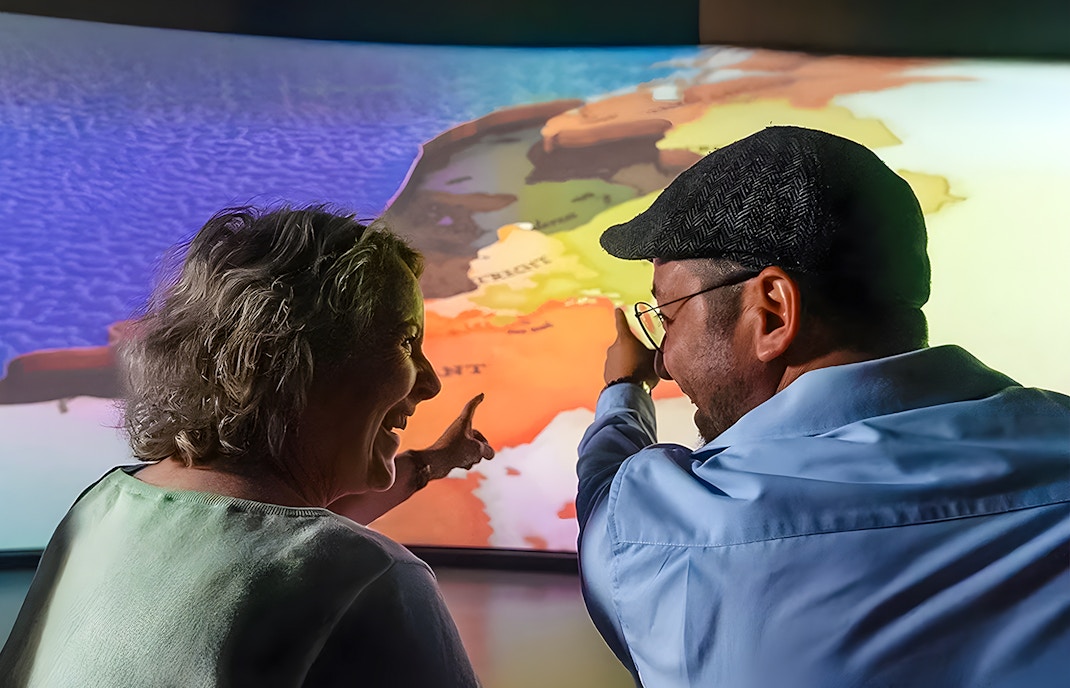 Tourists pointing at map during 5D ride at This Is Holland Ultimate Flight Experience.