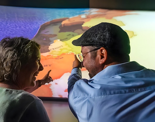 Tourists pointing at map during 5D ride at This Is Holland Ultimate Flight Experience.