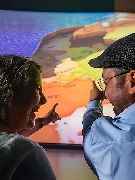 Tourists pointing at map during 5D ride at This Is Holland Ultimate Flight Experience.