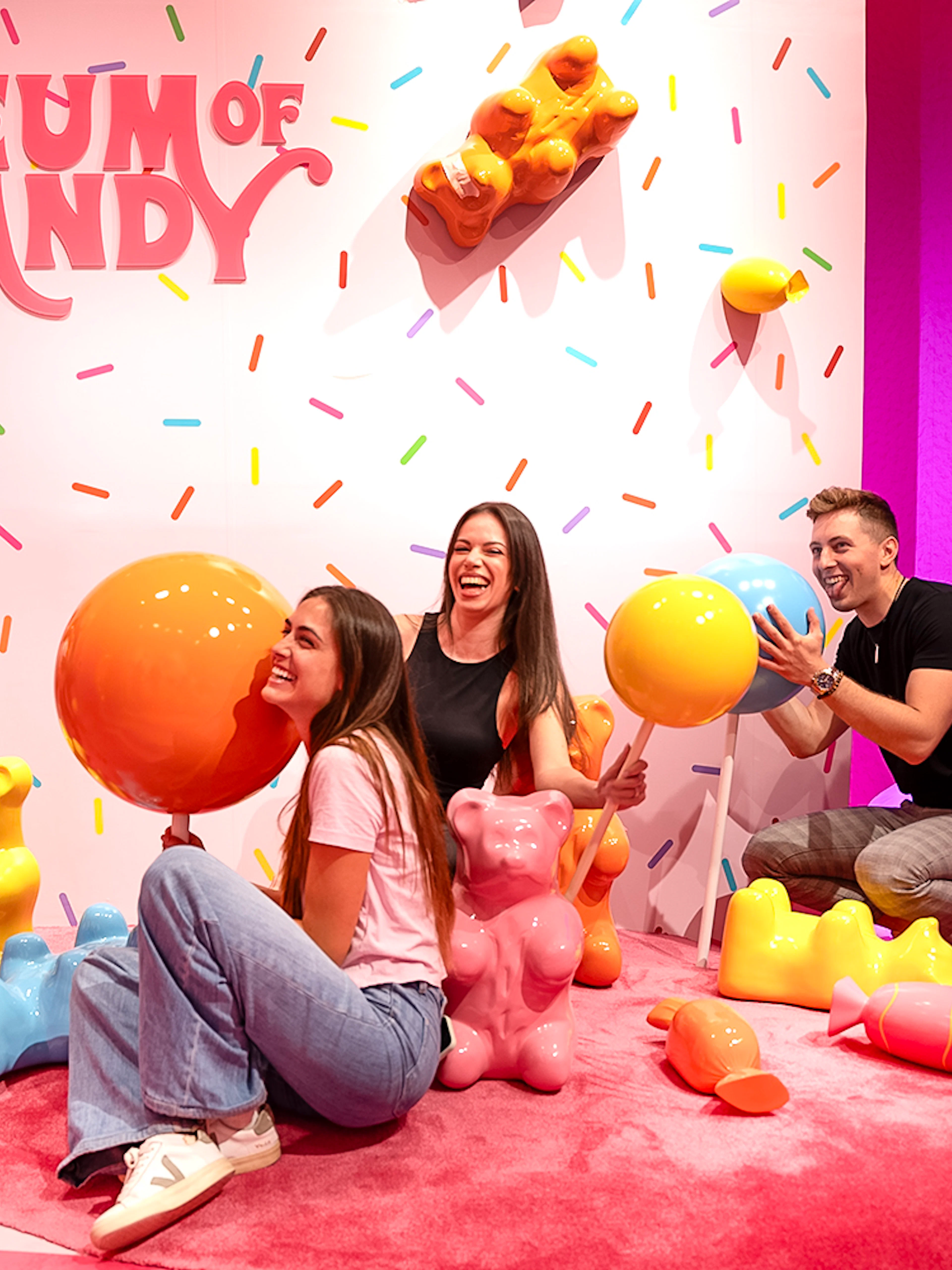 Guests interacting with giant candy sculptures at Museum of Candy, Dubai.