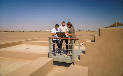 Visitors examining a display at the Mleiha archaeological site in the desert.