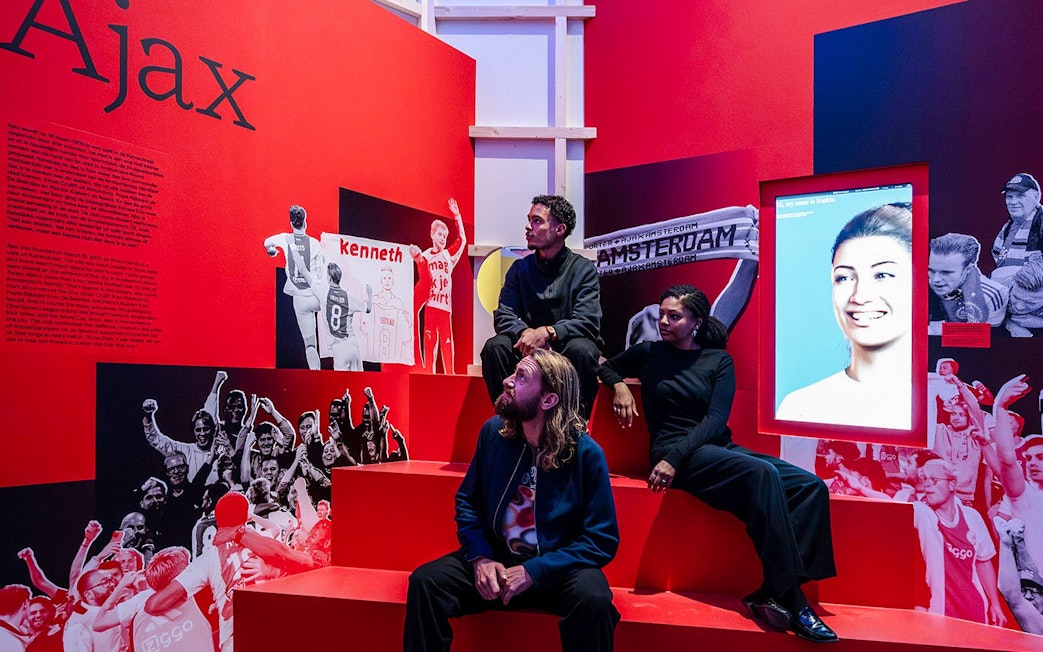 Visitors at the Amsterdam in Motion exhibit featuring Ajax football club history.