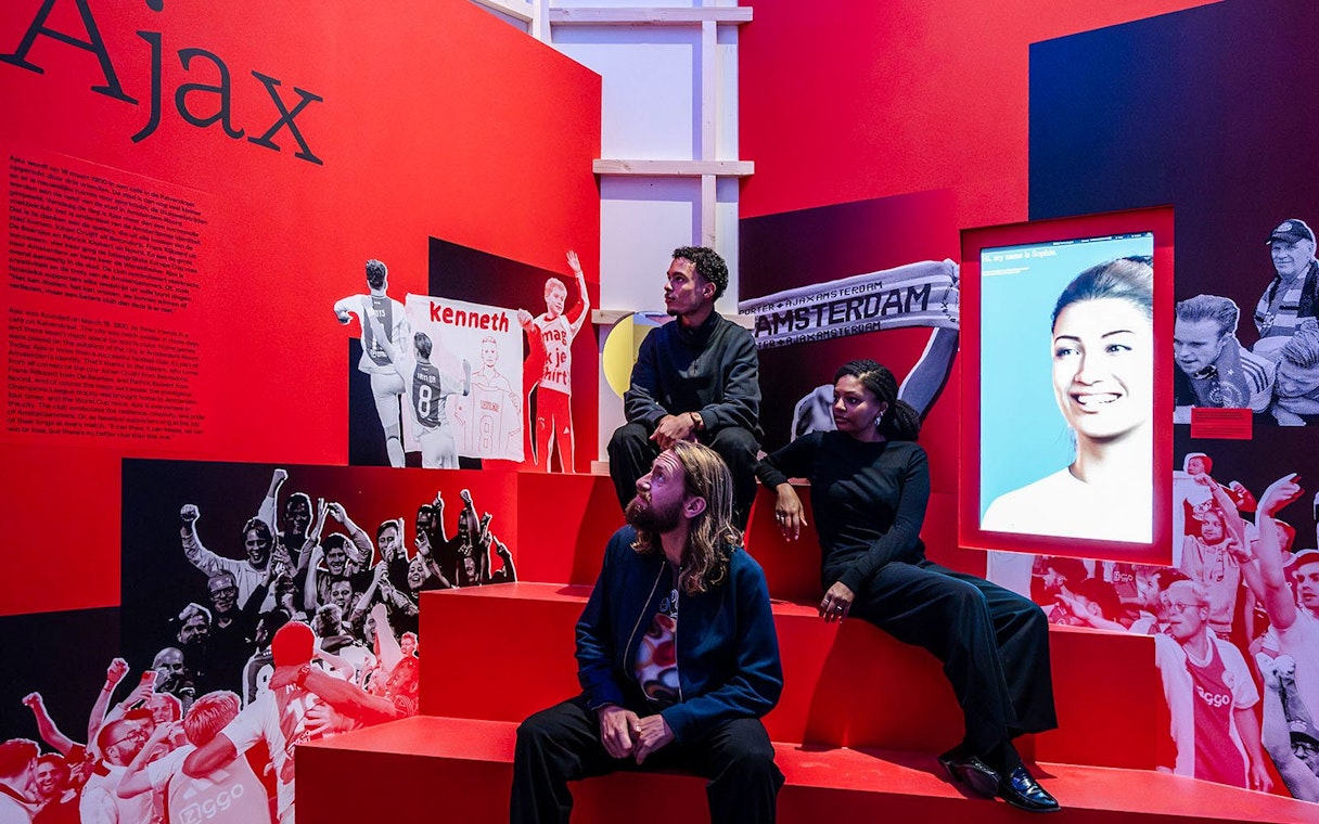 Visitors at the Amsterdam in Motion exhibit featuring Ajax football club history.