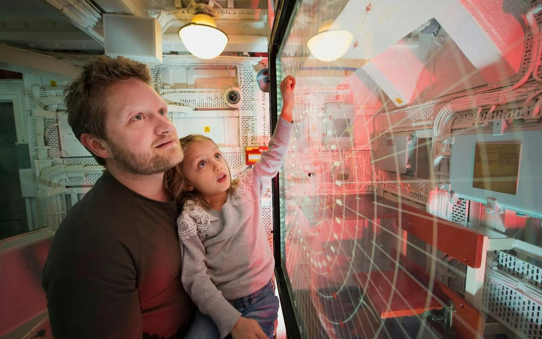 Father and daughter exploring radar room on HMS Belfast.