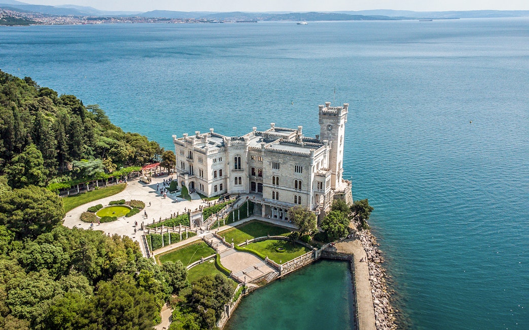 Miramare Castle overlooking the Gulf of Trieste, surrounded by gardens and sea.