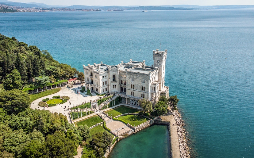 Miramare Castle overlooking the Gulf of Trieste, surrounded by gardens and sea.