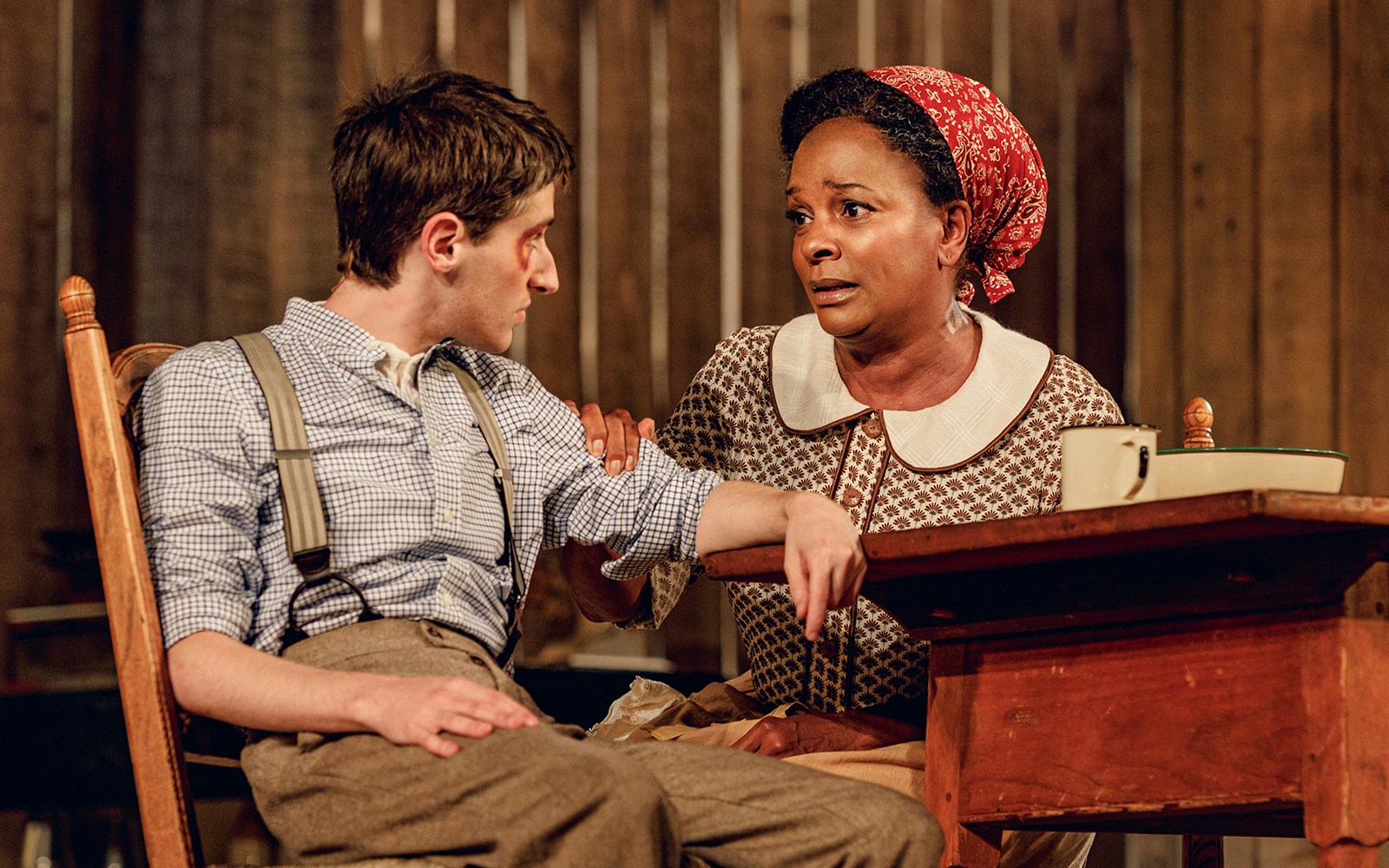 Two actors in a scene from "Purlie Victorious: A Non-Confederate Romp" at a wooden table.
