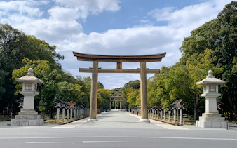 Torii gate at the entrance of a historical site in Nara, Japan, surrounded by trees.