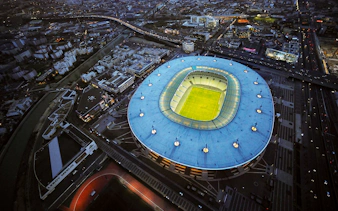 Aerial view of Stade de France in Saint-Denis, Paris, illuminated at night.