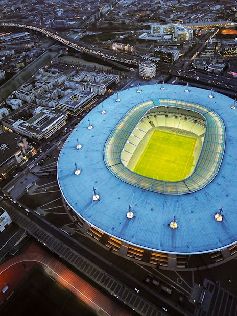 Aerial view of Stade de France in Saint-Denis, Paris, illuminated at night.