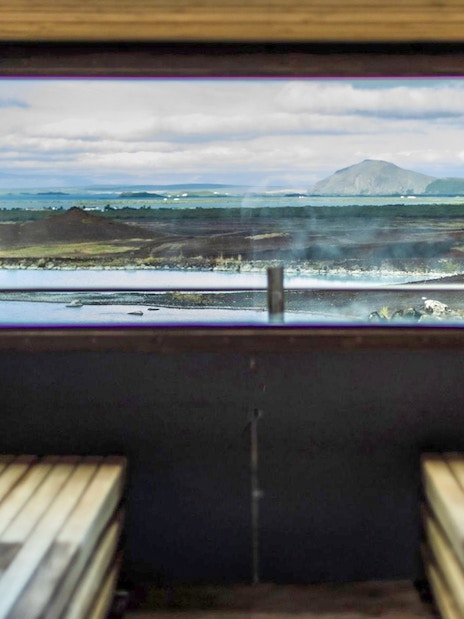 Sauna interior with view of Myvatn Nature Baths and Icelandic landscape.