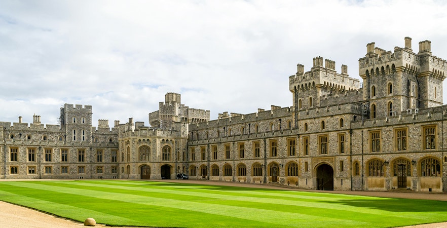 Windsor Castle courtyard with historic stone buildings and manicured lawn.