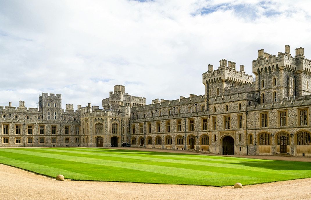 Windsor Castle courtyard with historic stone buildings and manicured lawn.