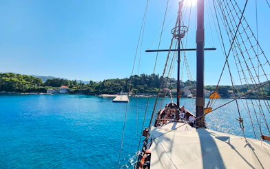 Sailing ship Karaka approaching Elaphite Islands, Croatia, with passengers on deck.