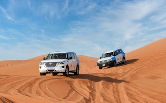 4x4 vehicles driving on sand dunes during Abu Dhabi desert safari.