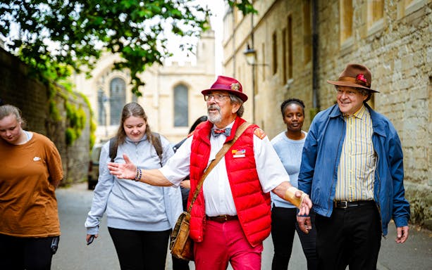 Guide leading tourists on a walking tour near historic buildings.