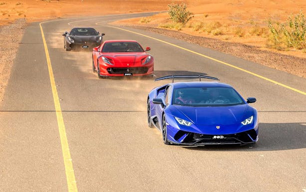Supercars driving on desert road, JNKD tour experience.