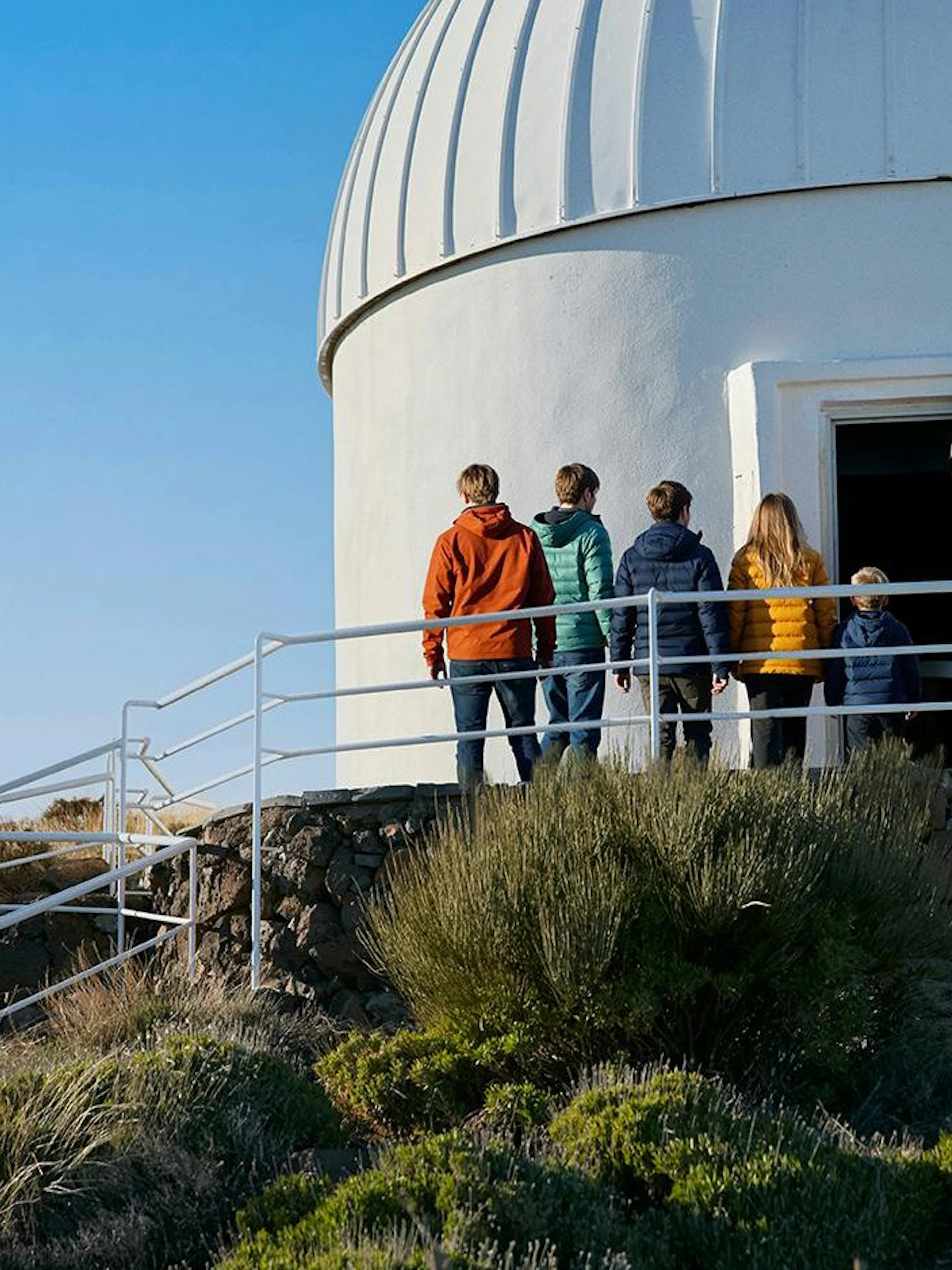 Visitors entering Teide Observatory dome during daytime tour.