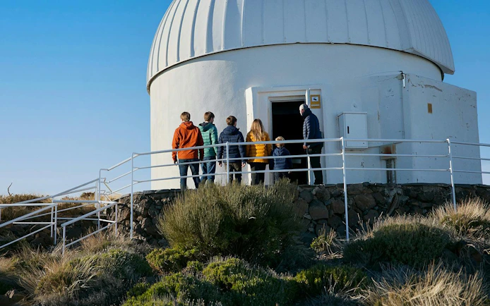 Visitors entering Teide Observatory dome during daytime tour.
