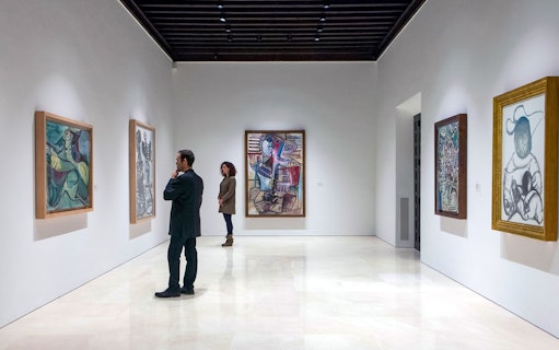 Visitors viewing paintings at Picasso Museum in Malaga.
